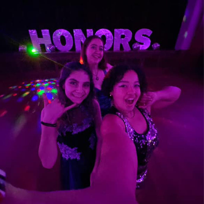 Three female honors students attending the Honors Student Board ball.