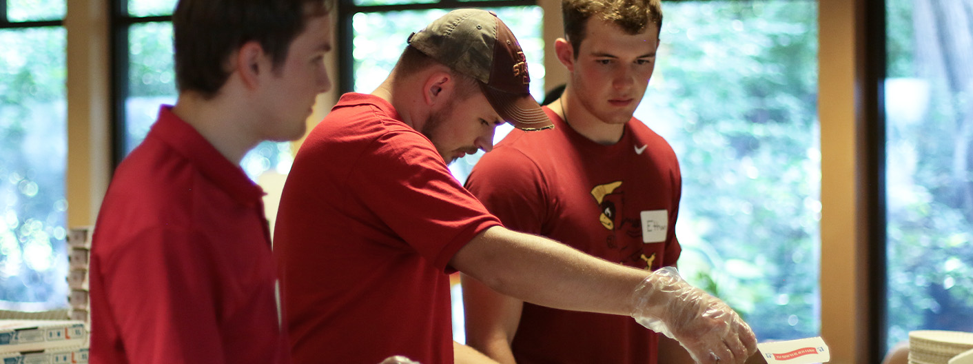 Honors Ambassadors helping serve pizza for FHP Kickoff.